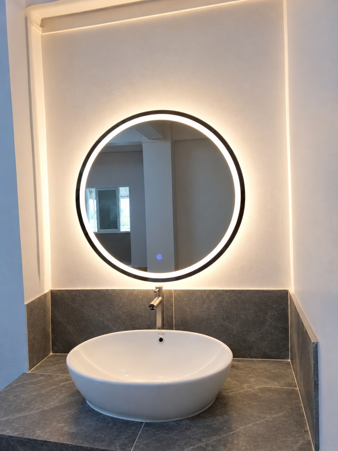 Round illuminated Adorable mirror above a wash basin
